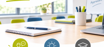 Une salle de formation avec un carnet, un stylo, un ordinateur et un tableau présentant les objectifs d’une formation de formateurs.